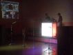 Dj, con cabina iluminada, pantalla de proyeccion con videos musicales